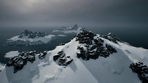 Majestic Icy Mountains Tower Over Frosty Waters and Volcanic Terrain