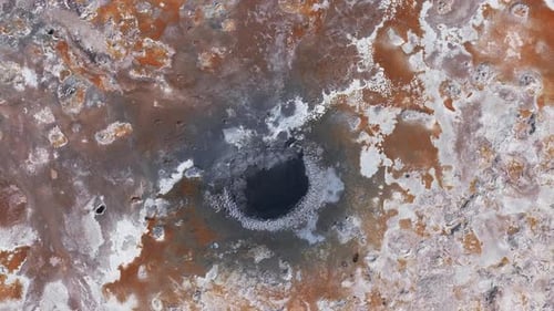Luftaufnahme des geothermischen Gebietes mit lebendigen Farben und dampfenden Lüftungsöffnungen