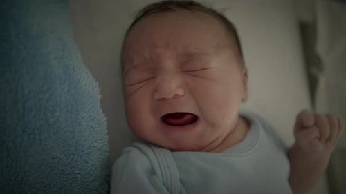 Crying Newborn Baby Lying in Hospital Bed
