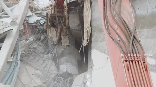 Une machine équipée d'un couteau démonte les décombres d'une arène détruite