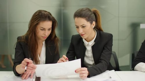 Team of Professionals Analyzing Paperwork in Office Setting