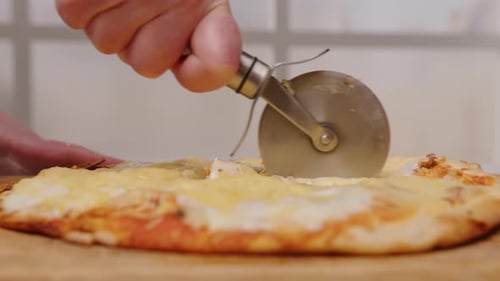 Close Up Slicing Homemade Pizza on Board