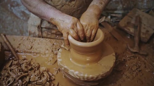 Potter travaille une pièce en argile rouge, taille moyenne