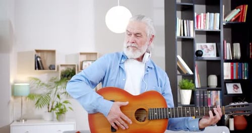 Senior Man Playing Acoustic Guitar at Home
