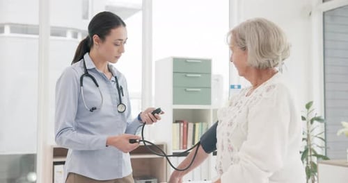 Health Worker Taking Senior Woman's Blood Pressure