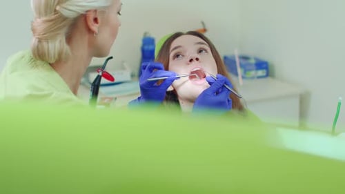 Mujer joven que se somete a un chequeo dental regular en un moderno y luminoso consultorio de dentista