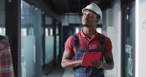 A Construction Worker Uses a Tablet in a Modern Office Blending Traditional Industry with Tech