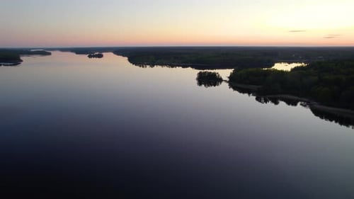 Aerial drone view of silhouette islands, colorful dusk sky, in the archipelago of Sweden