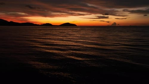 An aerial shot of a sunset over the ocean.