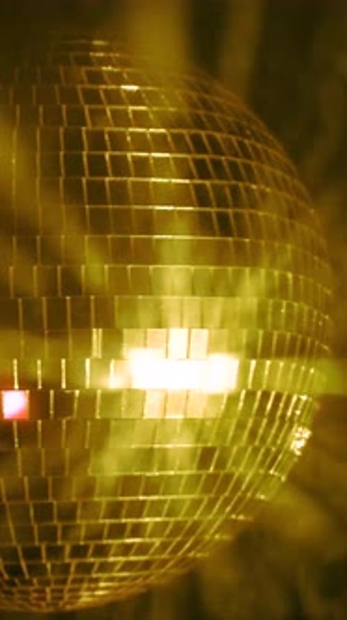 Dancing lights from a sparkling disco ball. Vertical