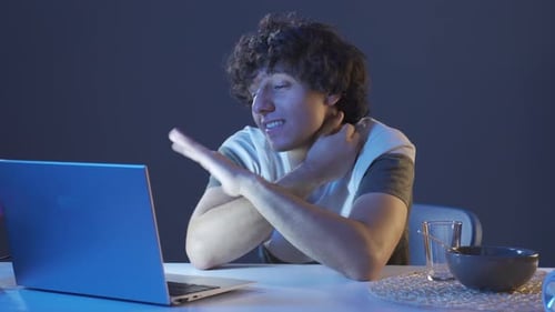 Young Adult Video Calling on Laptop at Night
