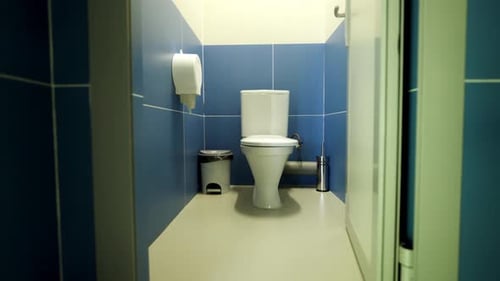 Toilettenständer in einer öffentlichen Toilettenkabine mit gefliesten Wänden