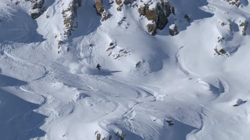 Following a slalom skier riding down rocky, powder snow slopes of the Alps of Tyrol