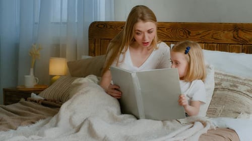 Woman and Child Reading a Book in Bed