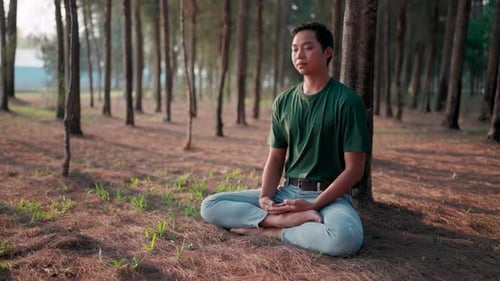 Man meditating in the park Sitting in the lotus position, practicing on a yoga mat