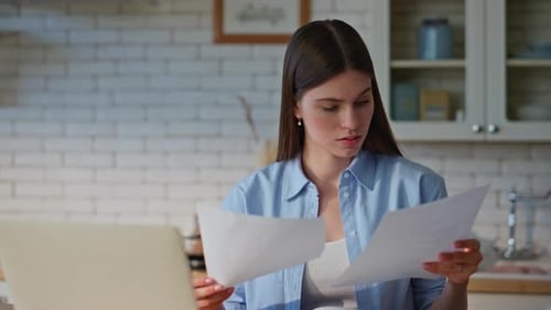 Exhausted Woman Examining Documentation Working at Kitchen Workplace Closeup
