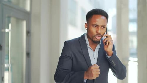 Angry Businessman Arguing on Mobile Phone Outdoors