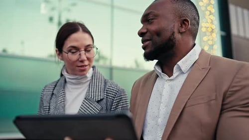 Colleagues Discussing Business on Tablet Outside Office