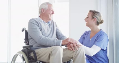 Caring Nurse Assists Senior Patient in Wheelchair