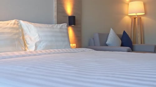 Pan across a luxury resort hotel bed.