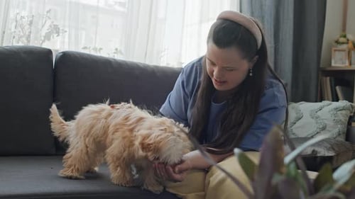 Woman playing with dog on the couch