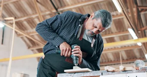 Drilling, wood and carpenter in workshop with tools for construction of project on table