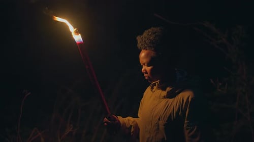 Lone Figure Holding Torch in the Night