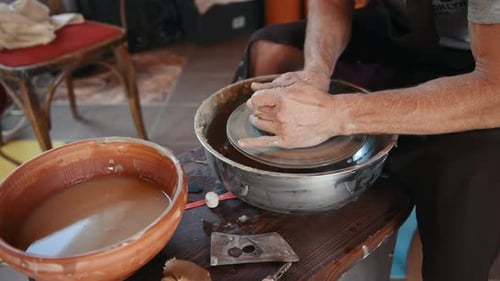 Der Keramiker verwendet eine Töpferscheibe und stellt ein handgemachtes Tonprodukt her