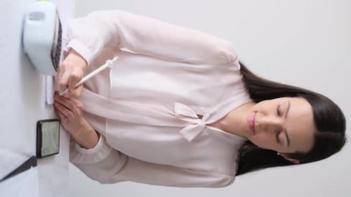 Brunette Woman Writing Note at Table Indoors