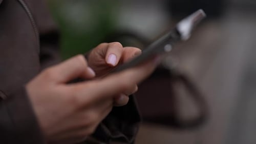 Closeup Cropped Shot of Unrecognizable Busy Woman Using Smartphone in City on Cloudy Day Showcasing