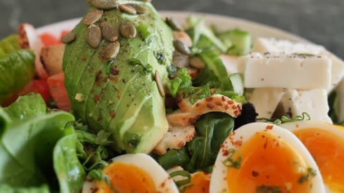 Fresh salad with avocado, egg, cheese, greens