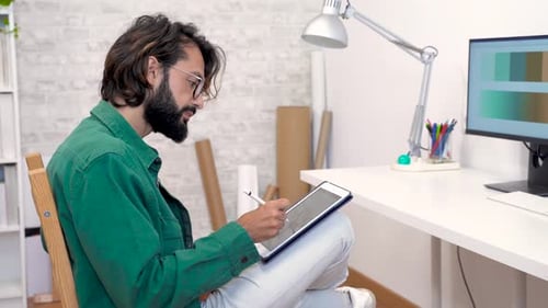 Young Adult Drawing on Tablet in Office