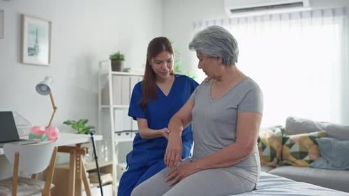 Young Woman Helping Senior Woman with Arm Exercises