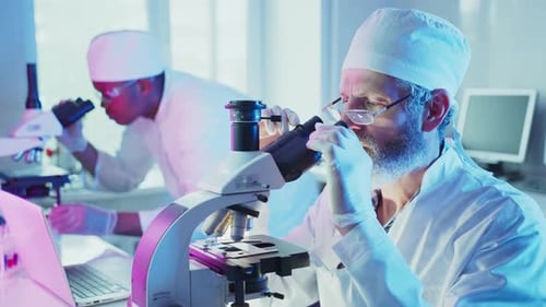 Leitender männlicher Wissenschaftler verwendet Mikroskop im Labor