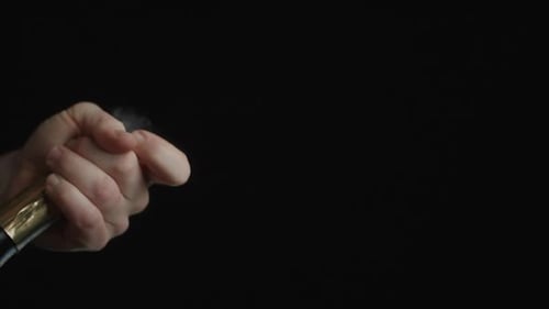 Hand Popping A Champagne Bottle Against A Dark Background