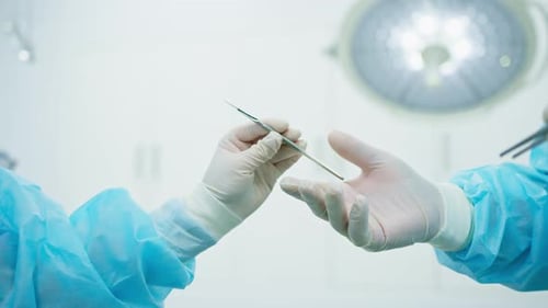Surgeon Passing Scalpel in Operating Room Environment