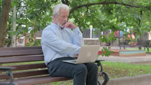 Senior Man Uses Laptop in the Park