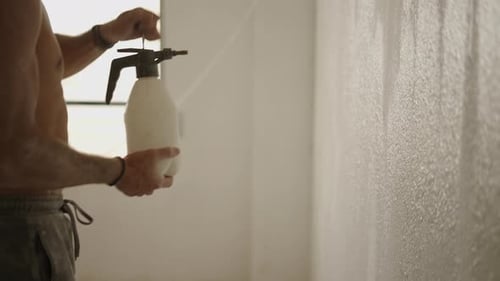 Person Sprays Water on Interior Wall