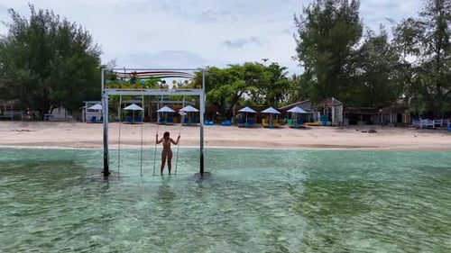 Woman on Beach Swing in Tropical Paradise
