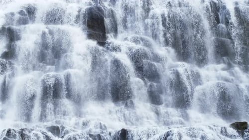 Majestic Tiered Waterfall Flowing Over Rocky Cliff