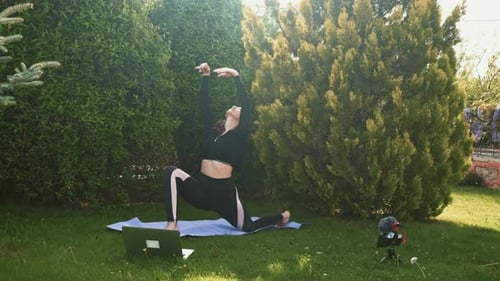Woman Doing Yoga Outdoors with Laptop and Phone