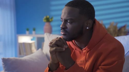 Thoughtful and stressed black man alone at home.