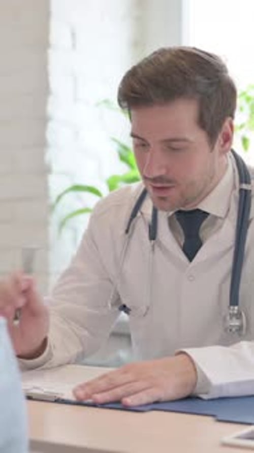 Adult Male Doctor in Office Talking to Patient