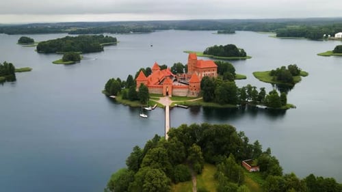 An aerial shot of the Trakai castle, medieval gothic Island castle, surrounded by green trees over