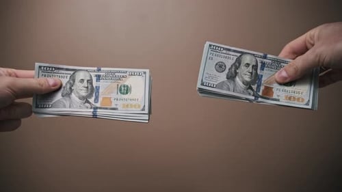 Hands Exchanging Stacks of One Hundred Dollar Bills