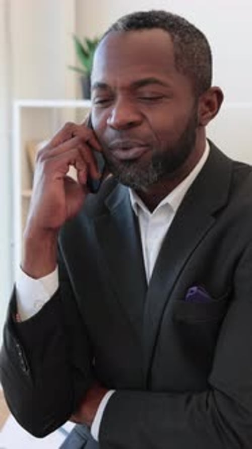 Man in Suit Talking on Cell Phone Indoors
