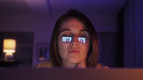 Close Up View of Focused Woman Wears Computer Glasses Looking at Laptop Screen with Computer