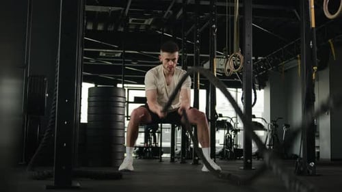 Starker, muskulöser kaukasischer Sportler, funktionelles Training für Herren, sorgt mit Battle Ropes Sport für Furore