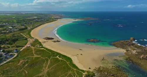 Aerial View of the Tranquil Beach at Plage Des Amiets with Clear Turquoise Water and Waves
