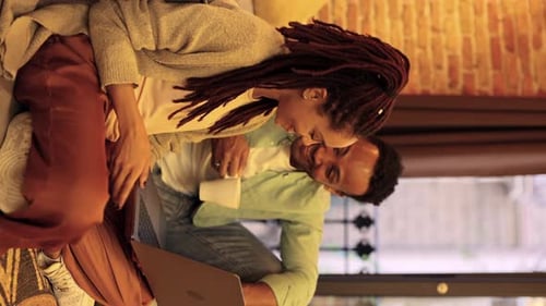 Jovem casal hispânico africano em casa assistindo filme no computador